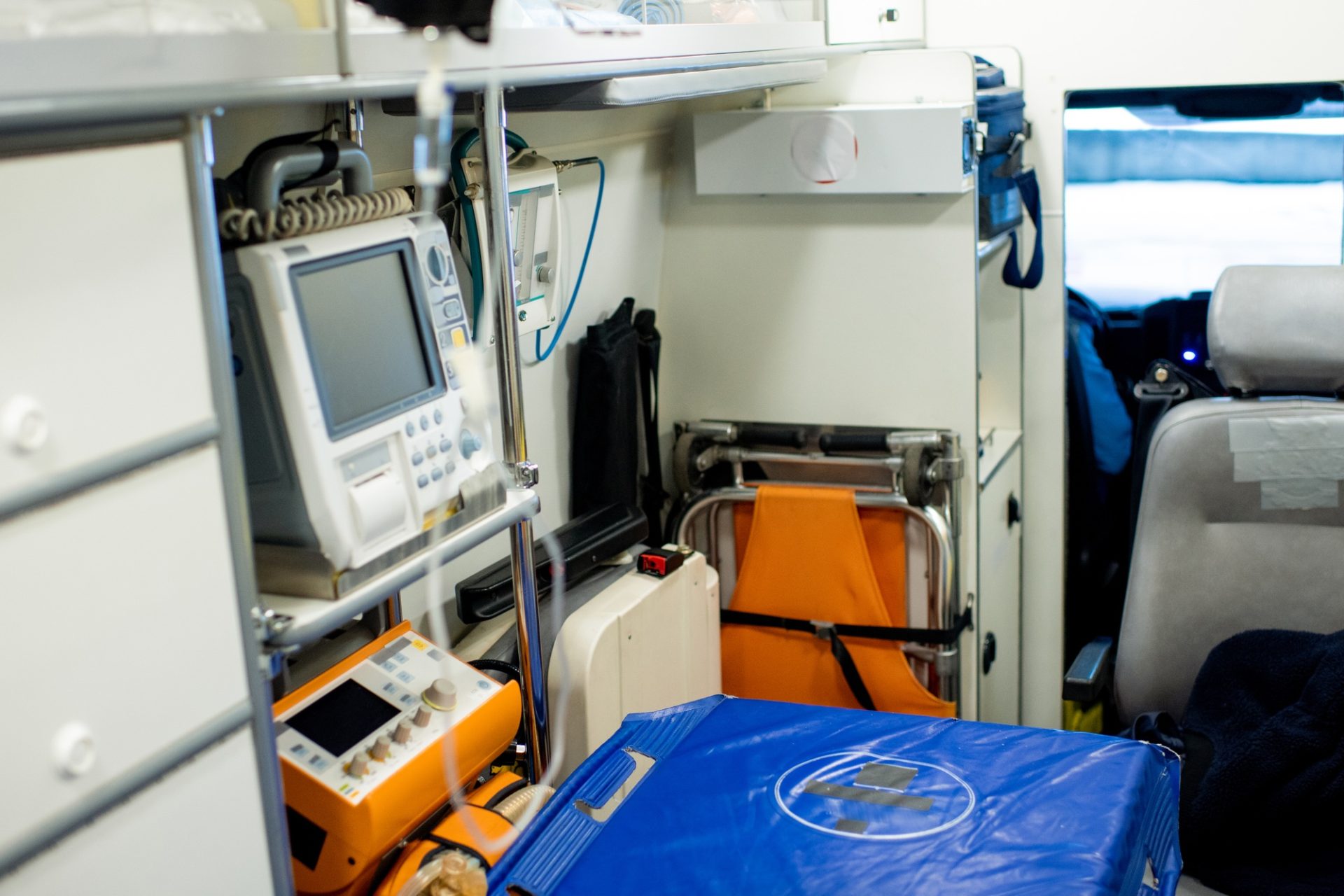 Stretcher by first aid medical equipment and other stuff inside ambulance car